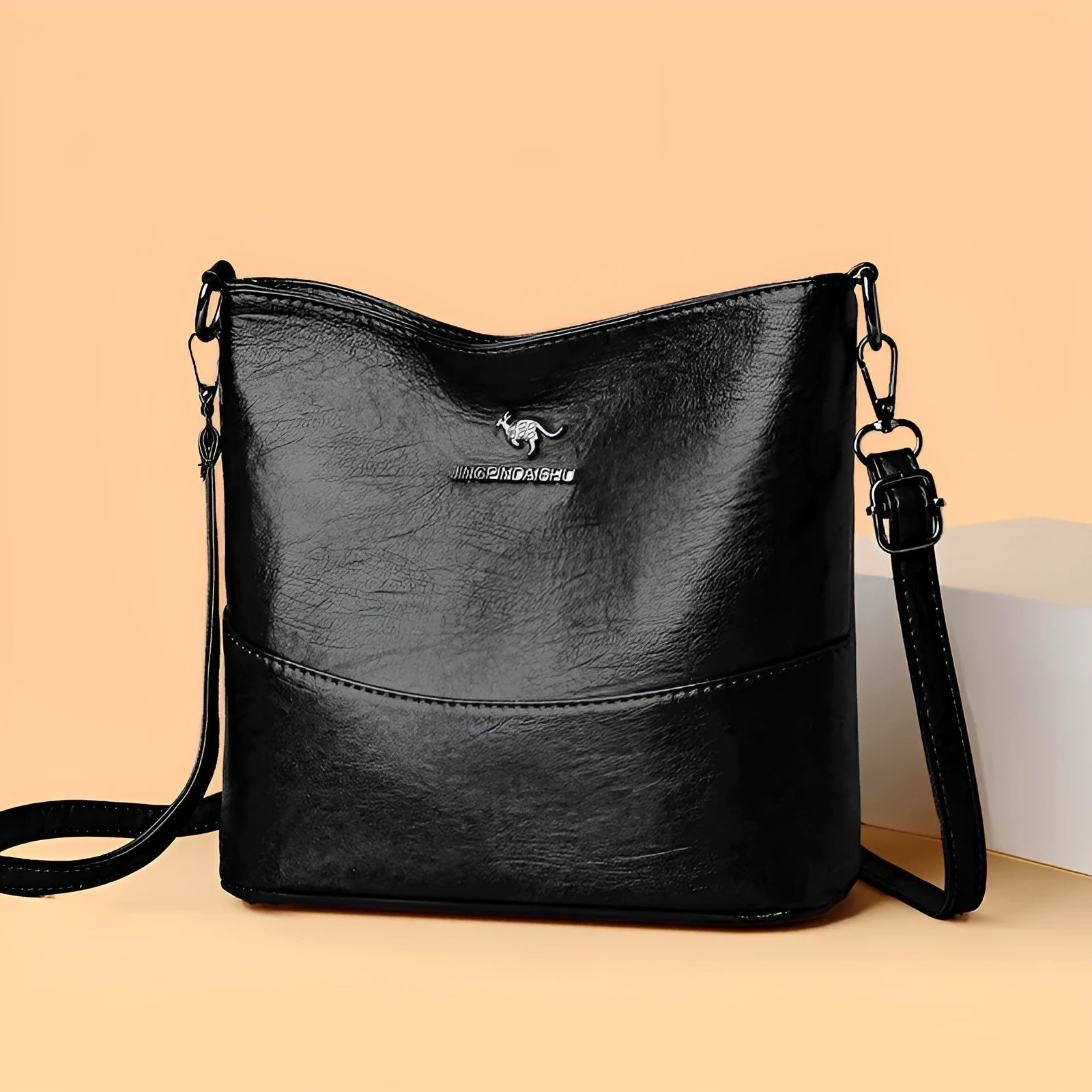 Women's soft leather bucket shoulder bag in black with visible sewing lines and phone compartment