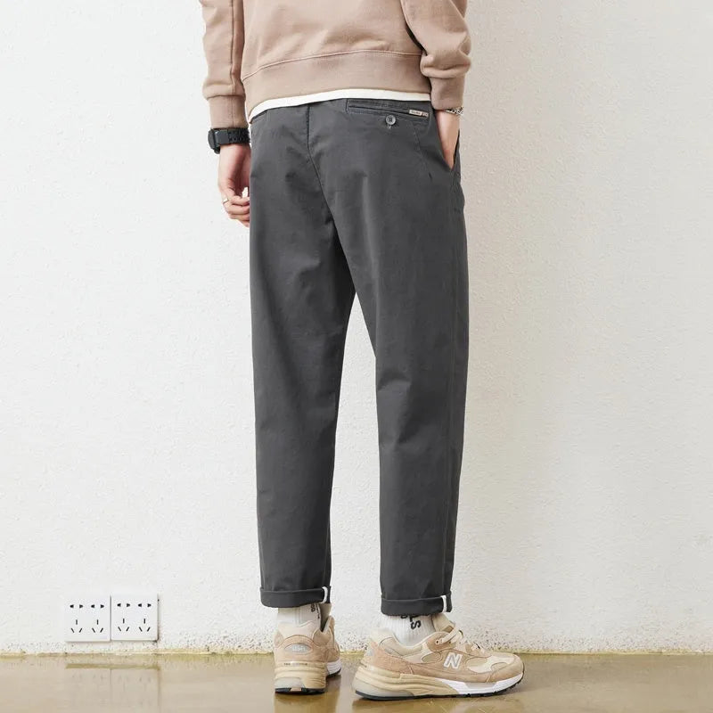 Men's loose wide-leg casual pants in dark khaki with zipper fly and mid-rise waist on a plain background