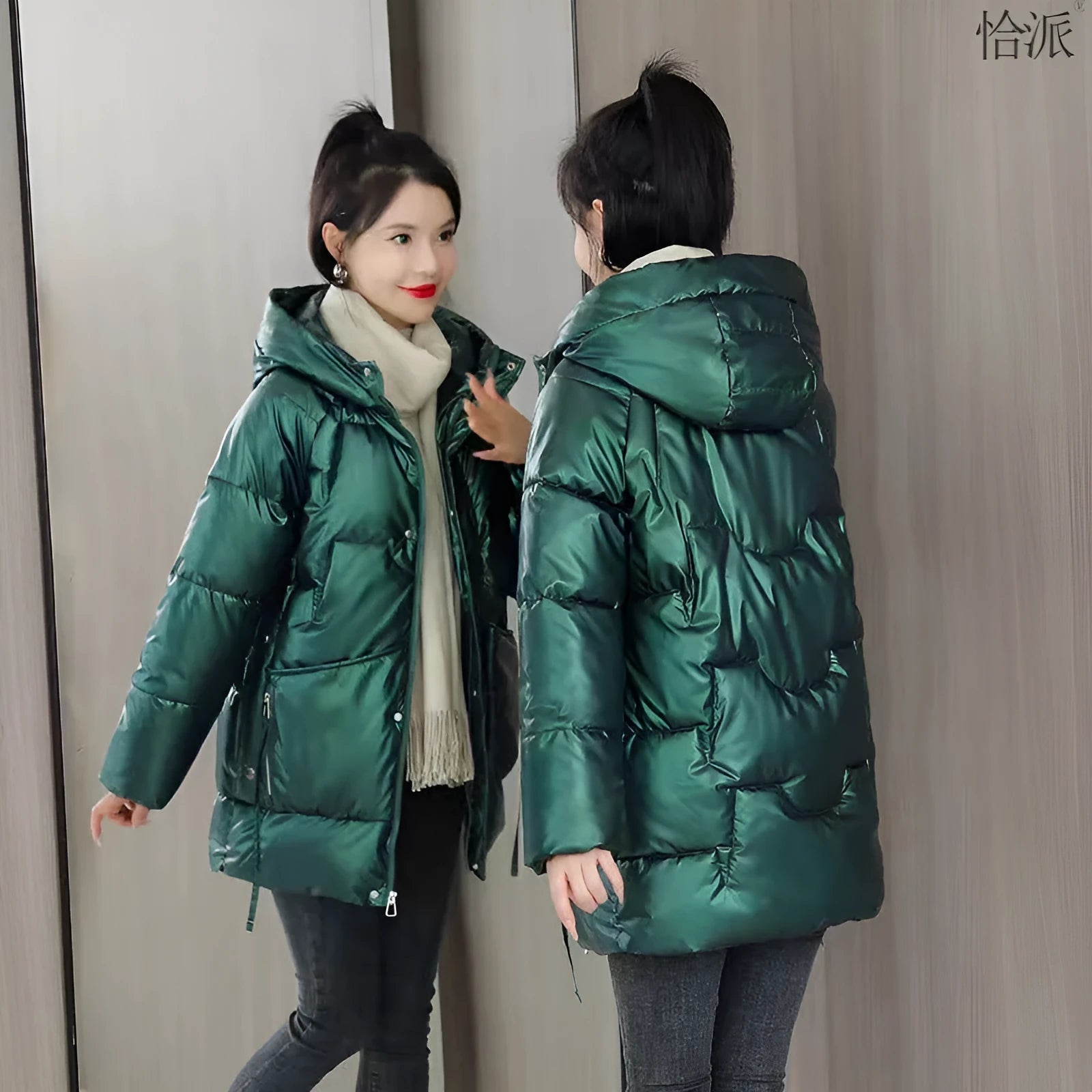 Green loose-fit hooded winter jacket for women on a hanger, showing long sleeves.