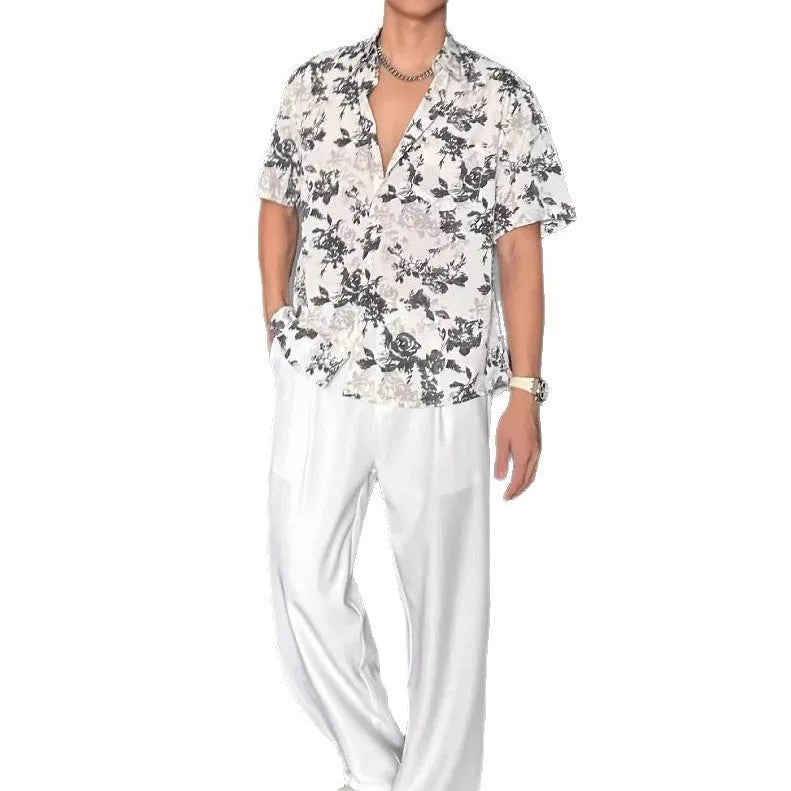 Loose black floral print short sleeve casual shirt on a hanger.