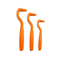 Three tick hook removers for dogs in different colours on white background
