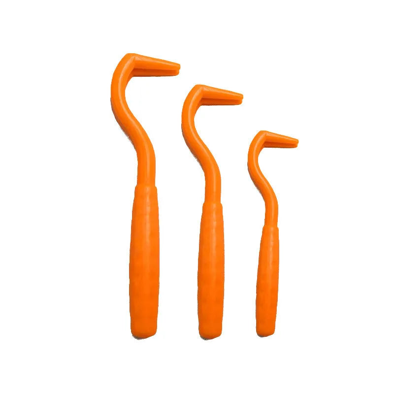Three tick hook removers for dogs in different colours on white background