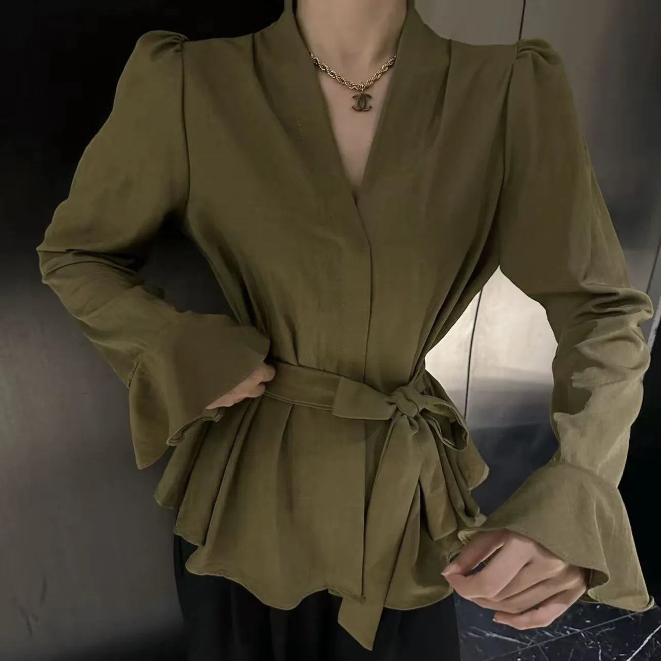 Women's black French-style shirt with irregular collar and long tied bell sleeves.