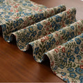 Dark blue striped jacquard table runner with tassel trim laid on a wooden table