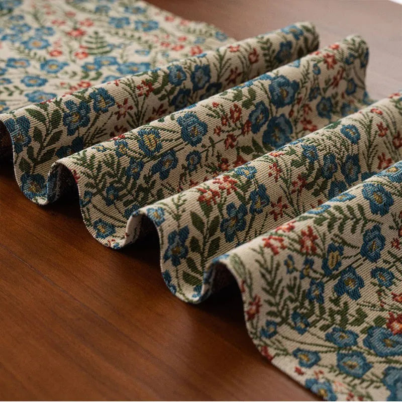 Dark blue striped jacquard table runner with tassel trim laid on a wooden table