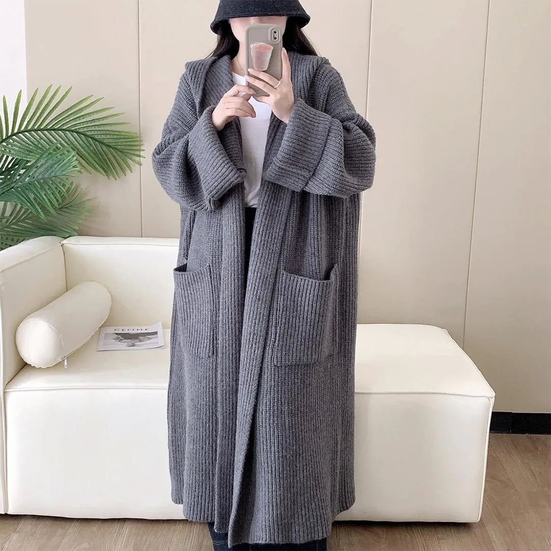 Loose grey hooded cardigan coat with raglan sleeves shown on a hanger.