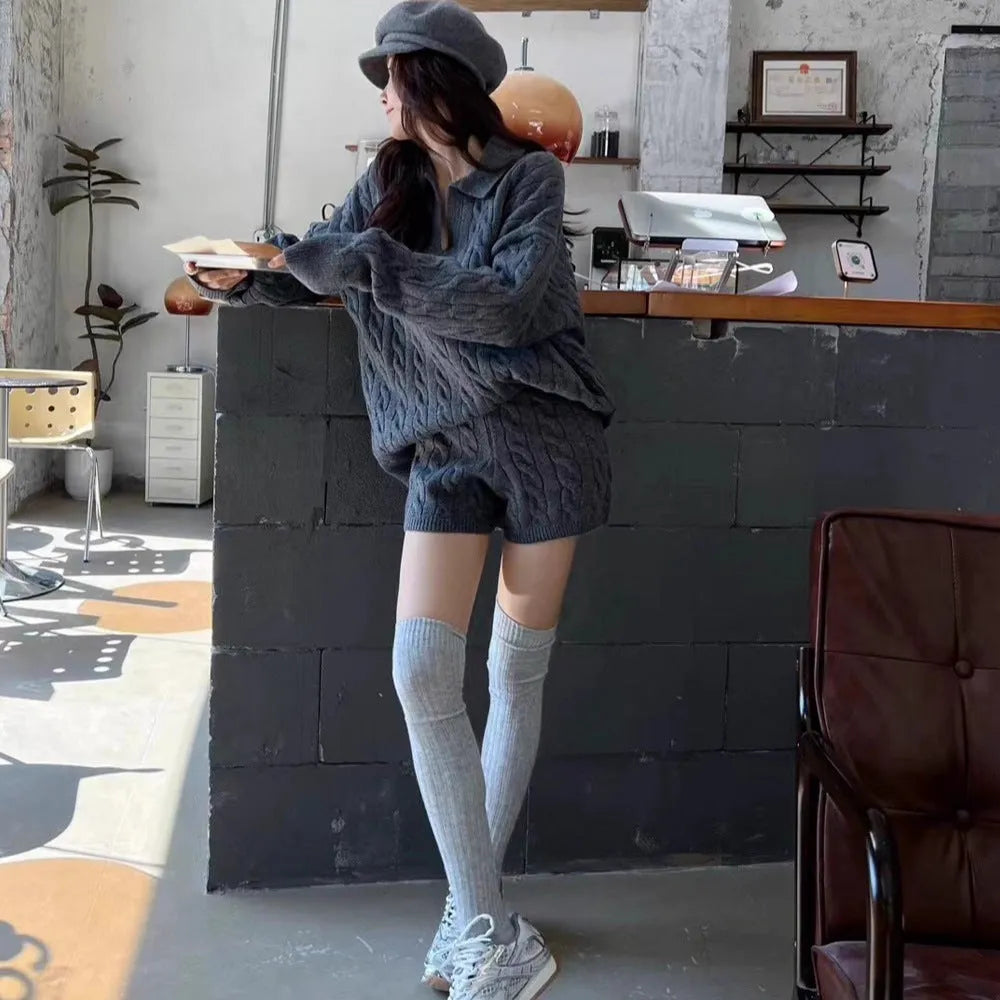 Creamy-white women's knitted cable-knit sweater and shorts set on a hanger.
