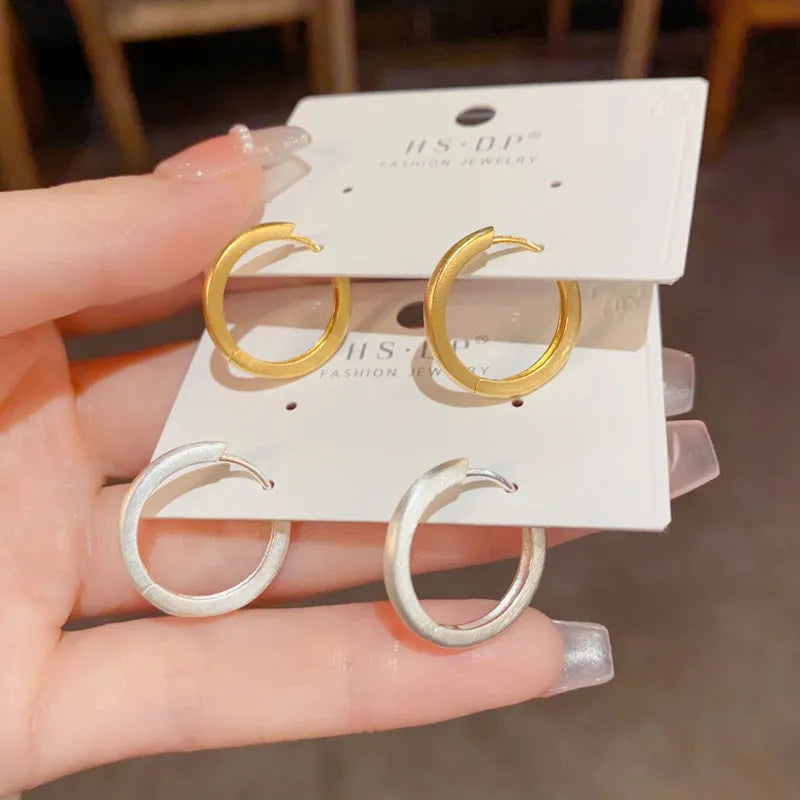 A pair of round geometric clip-on earrings for women in gold or silver plating.