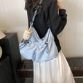 Green pleated polyester crossbody bag showing split pocket design and foldable construction