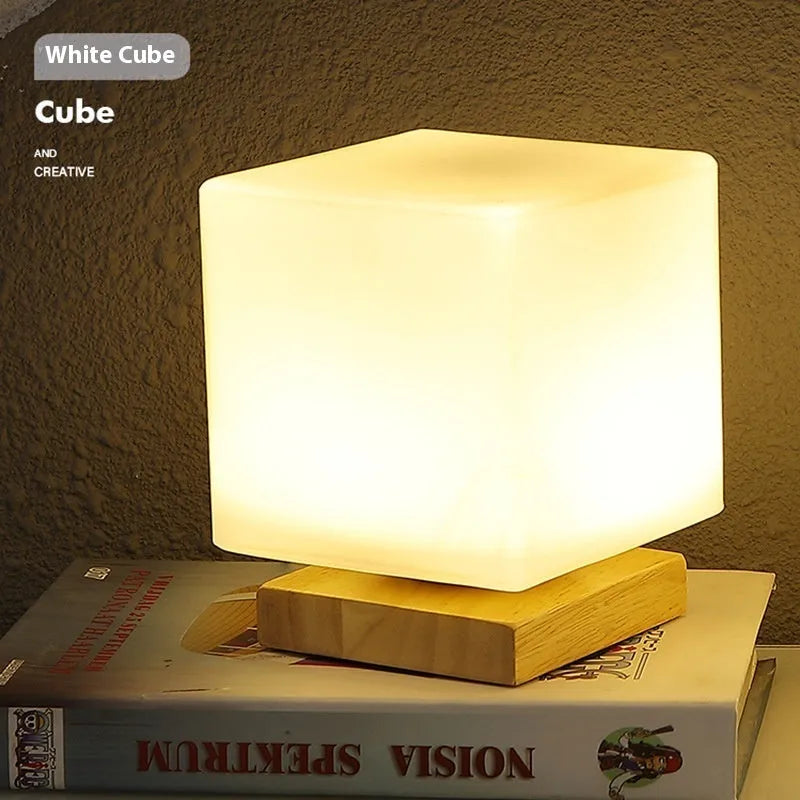 Nordic white geometric table lamp with solid wood base and USB charging port on a wooden desk.