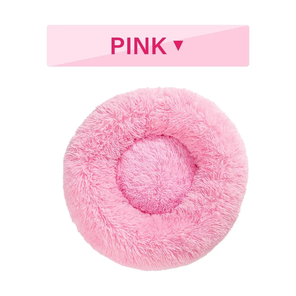 Fluffy donut-shaped dog bed in light grey plush material, showing raised rim and central cushion.