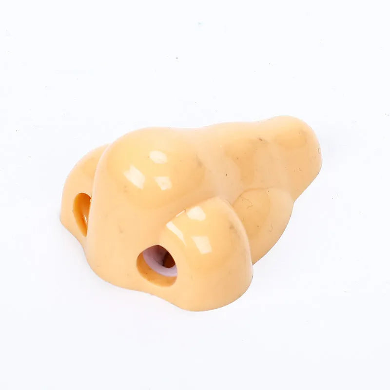 Flesh-colour plastic manual pencil sharpener with a large nostril and geometry-shaped body.