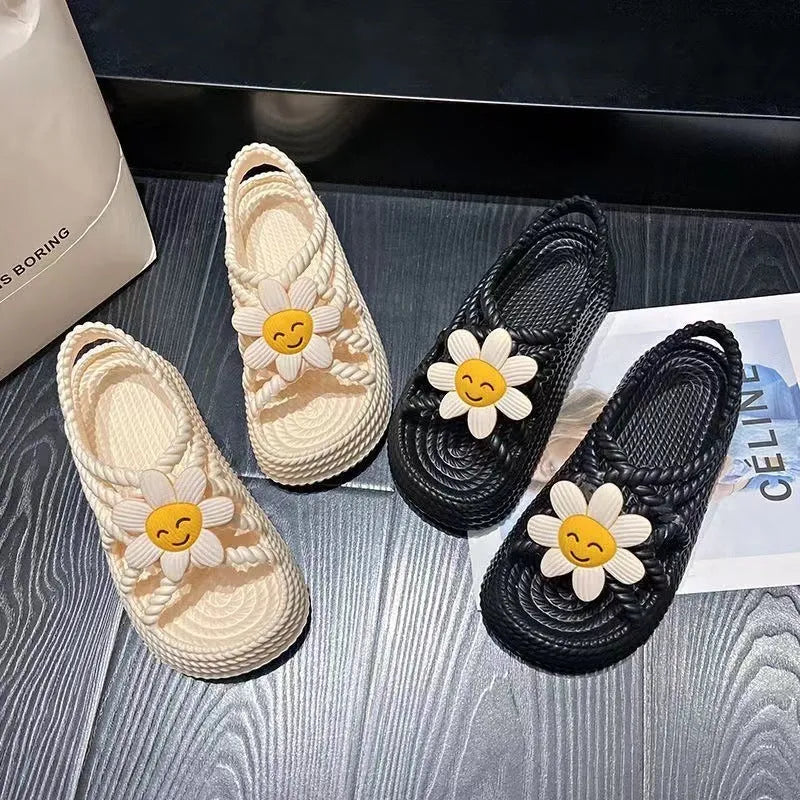 Beige PVC sandals with flower embellishments and a round toe, on a non-slip sole.