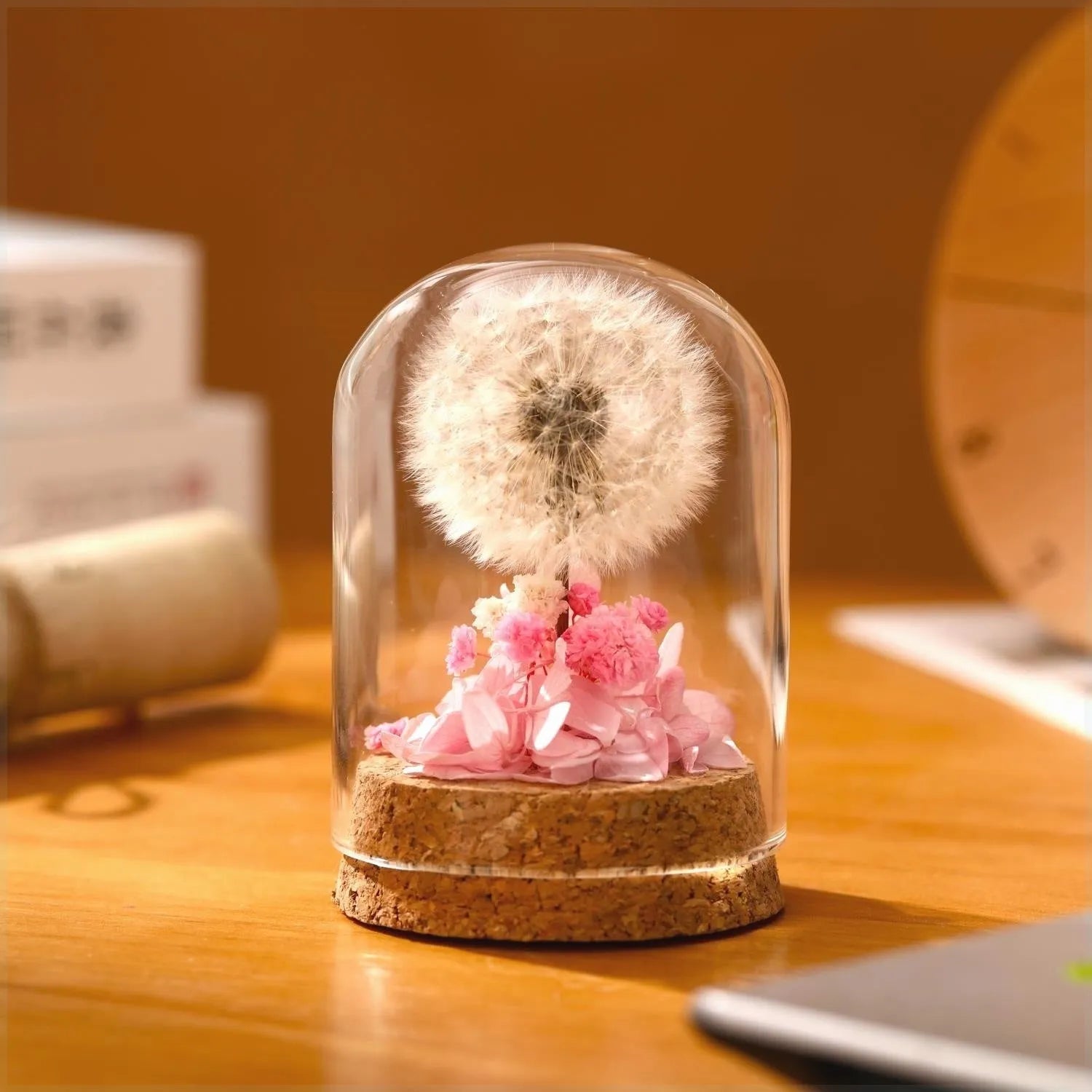 Dandelion-shaped glass night light ornament in gradient colours on wooden surface