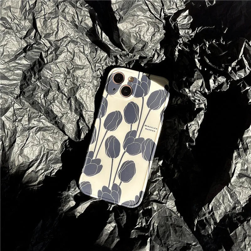 Black silicone iPhone case with a raised embossed tulip flower design on the back.