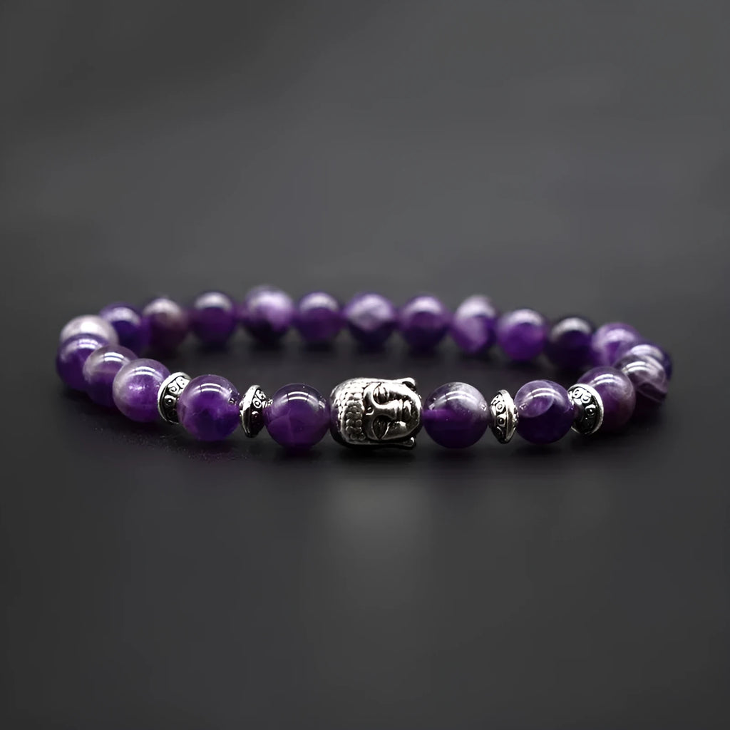 Close-up of a manual processed bracelet with a Buddha head bead, shown in amethyst, on a wrist.