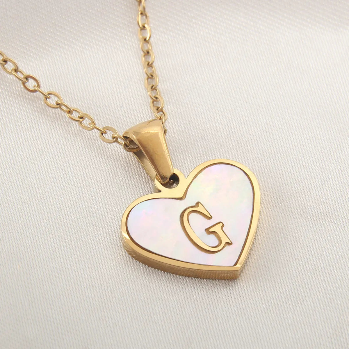 Gold plated chain necklace with a white shell heart-shaped pendant personalised with a single letter initial.