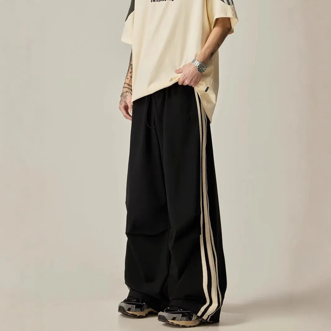 Black men's high waist wide leg climbing trousers on a hanger.