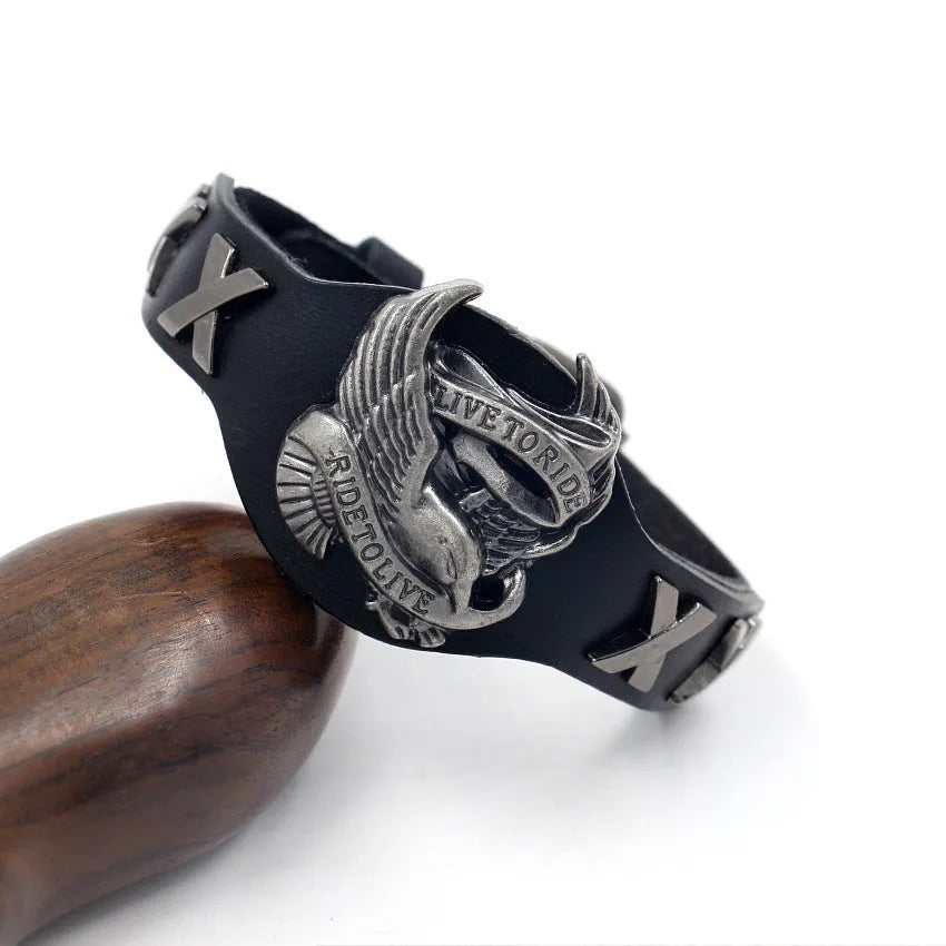 Black geometric bracelet with eagle watch-button closure on leather strap showing adjustable width design
