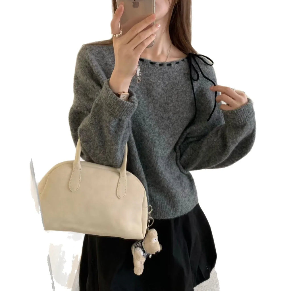 A grey loose-fitting women's knitwear pullover, shown on a hanger.