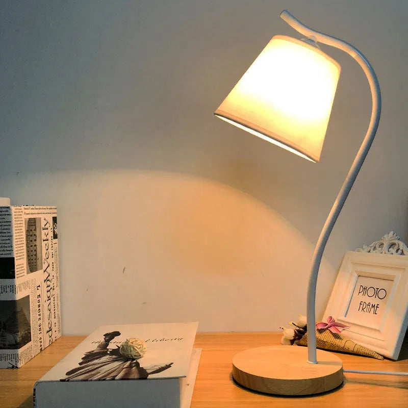 A modern LED table lamp with a push button dimmer switch on its base.