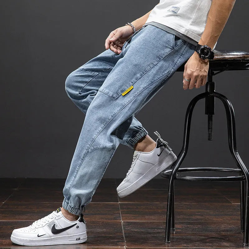 Men's loose blue cargo jeans with straight leg on a neutral background.