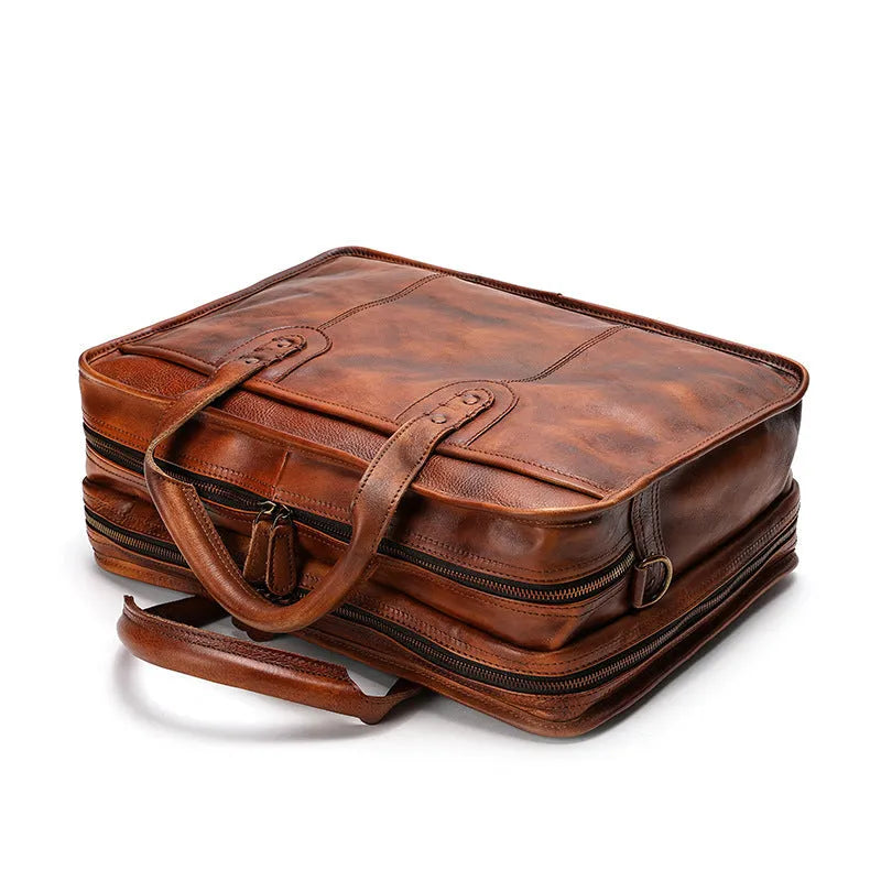 Large vintage leather men's briefcase showing internal laptop, document, camera, and phone compartments