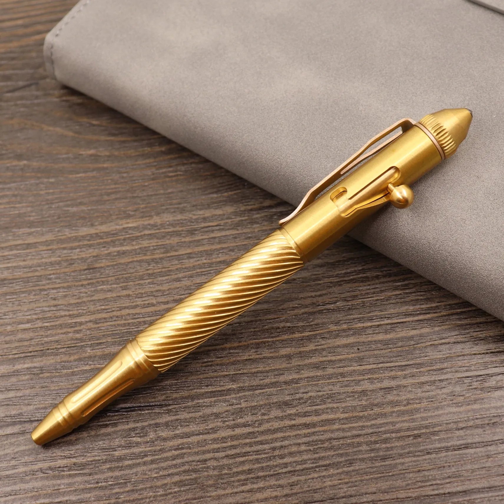 Brass bolt action tactical pen with cylindrical design and six-ring grip pattern