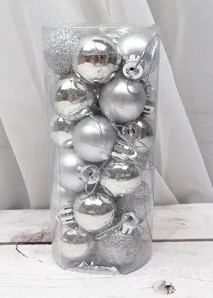 Assortment of 3cm gold, red, silver, and blue plastic Christmas baubles next to their tall storage barrel.