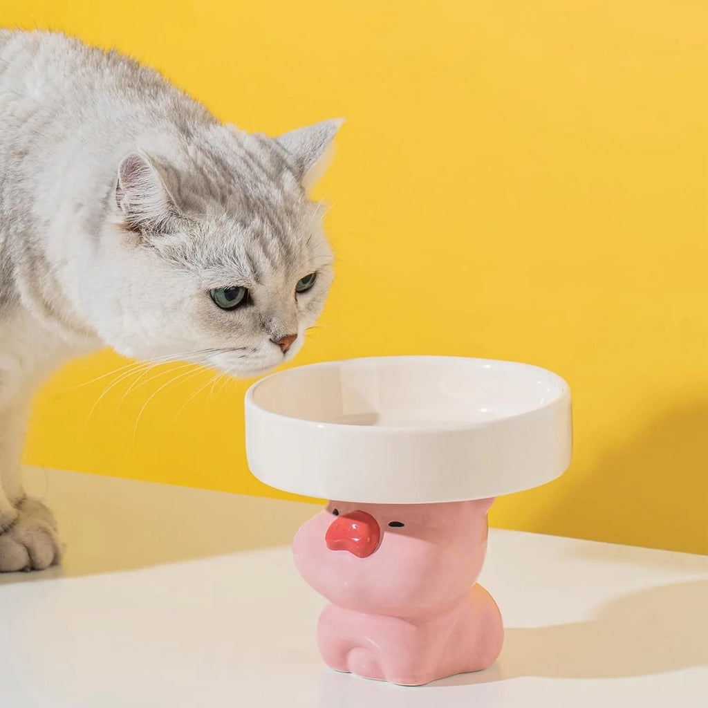 Raised ceramic cat bowl with animal design in pink, yellow, or white, showing wide rim.