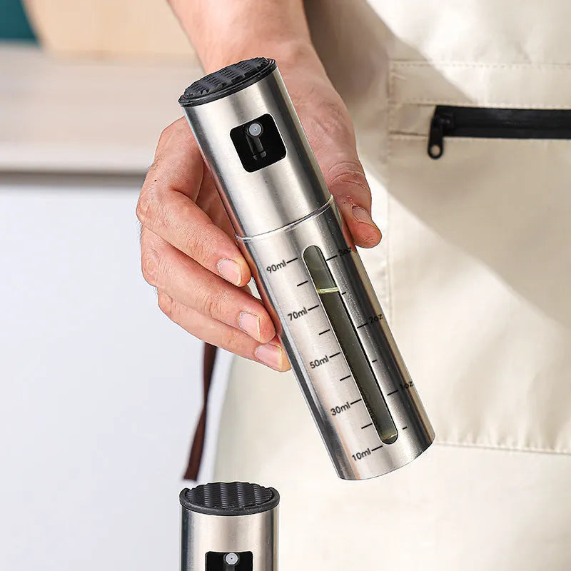 Press-type stainless steel oil spray bottle with 100ml capacity and glass body for kitchen use