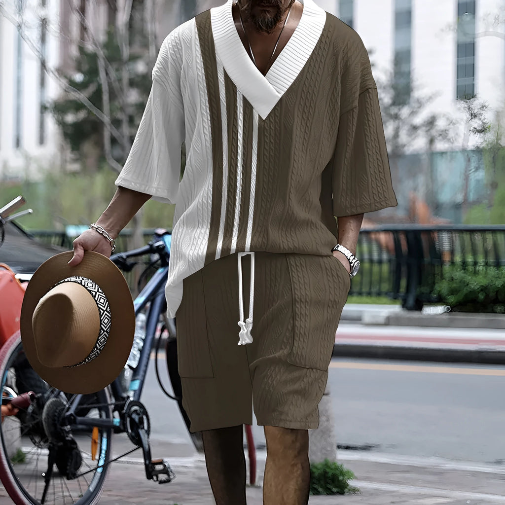 Man wearing a printed drop-shoulder knitted short-sleeved top with matching shorts in a solid colour.