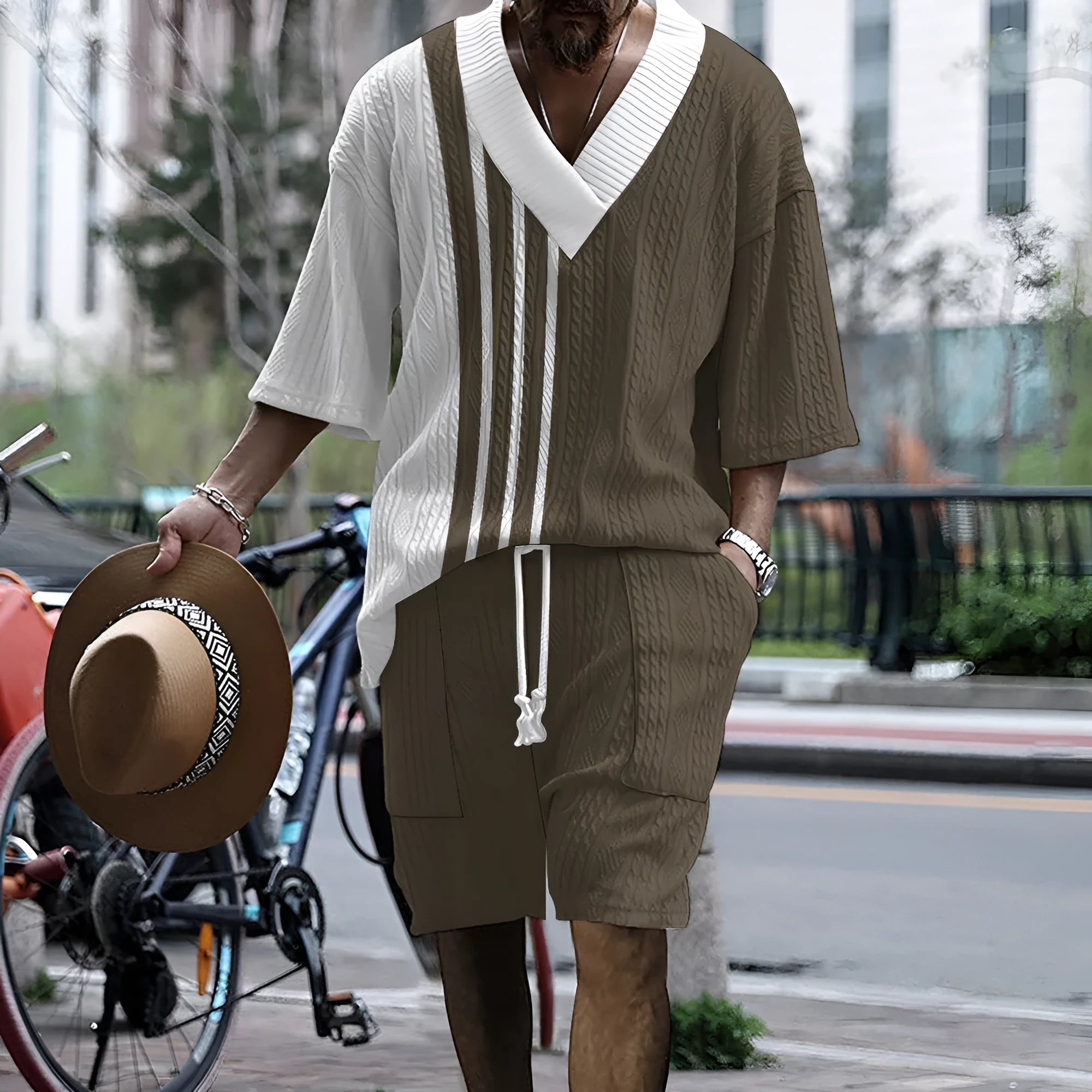 Man wearing a printed drop-shoulder knitted short-sleeved top with matching shorts in a solid colour.