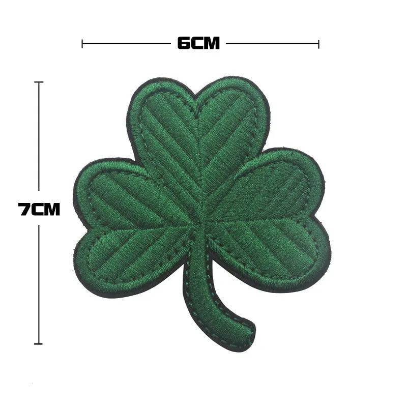 Embroidered fabric badge with Velcro backing showing military-style clover and skull flower designs