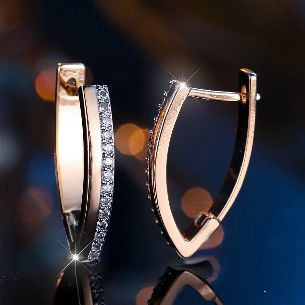 Women's geometric V-shape ear clips in champagne gold with white diamond detail on copper construction