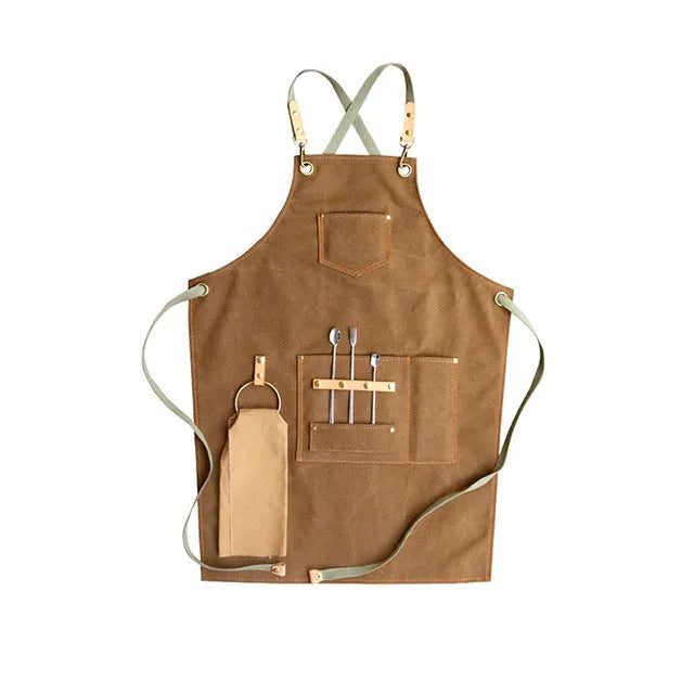 Canvas apron with cross-back straps in camel colour.