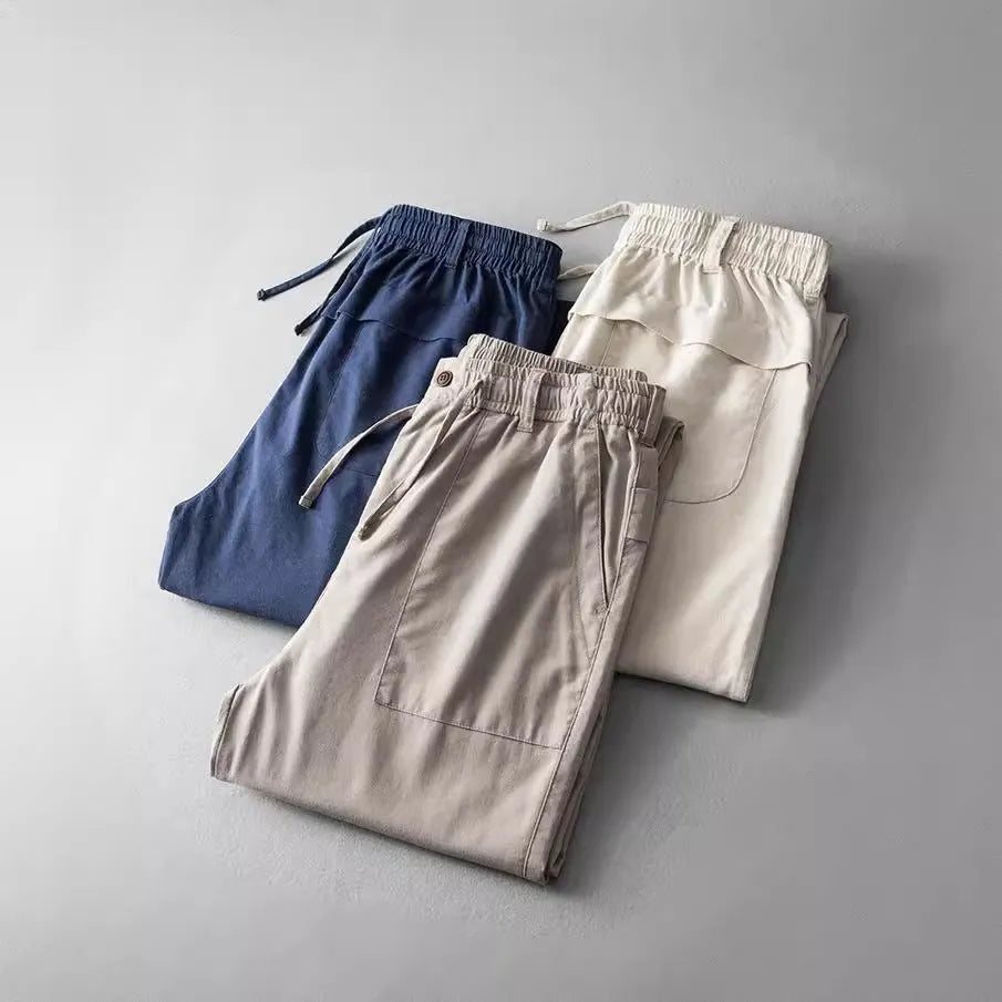 Men's solid colour linen casual trousers in mid-waist fit shown in grey, navy, or apricot.