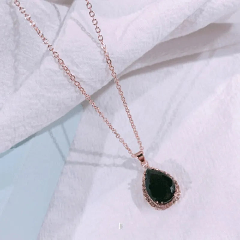 Water drop shaped geometric pendant necklace with rhinestone detailing in rose gold pink colour