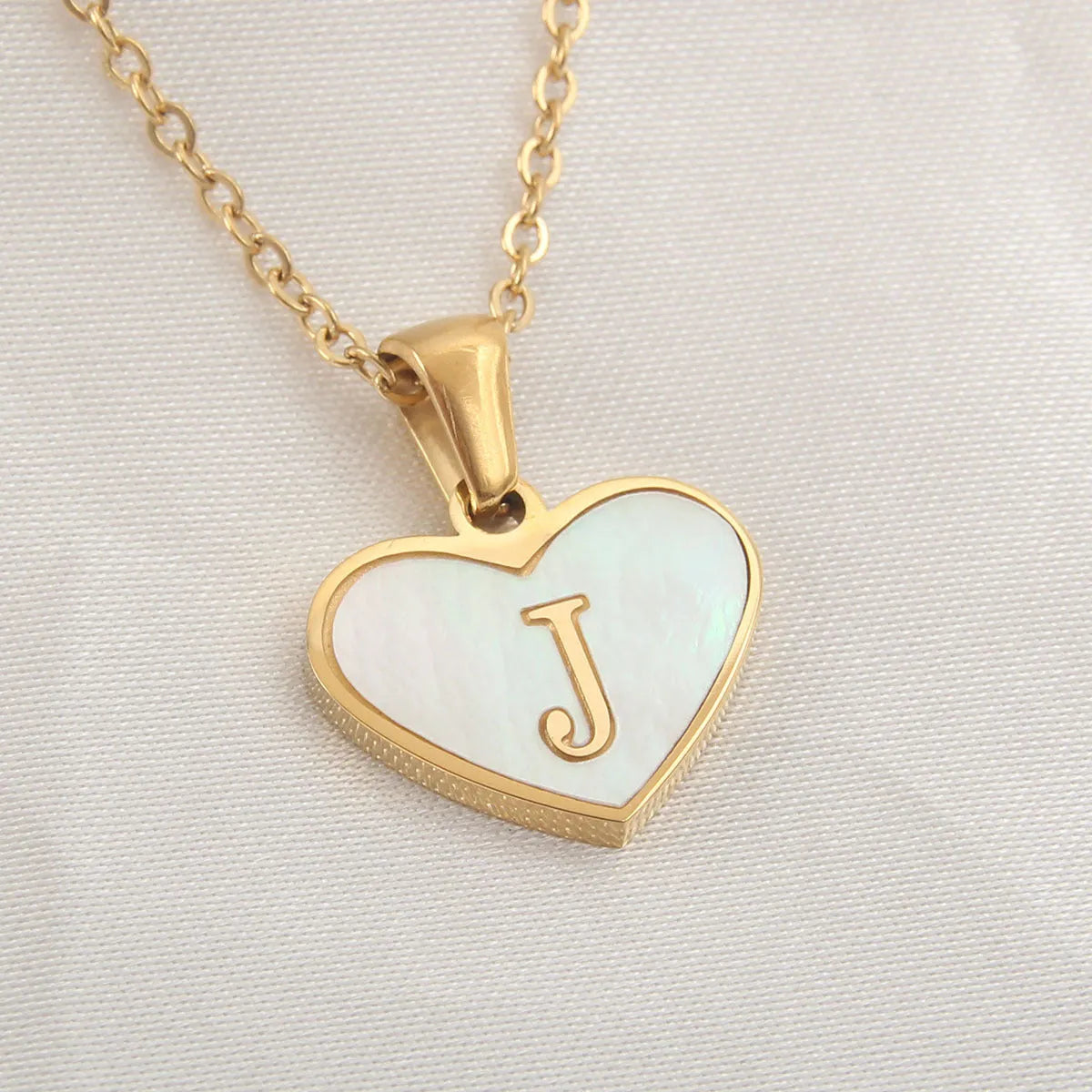 Gold plated chain necklace with a white shell heart-shaped pendant personalised with a single letter initial.