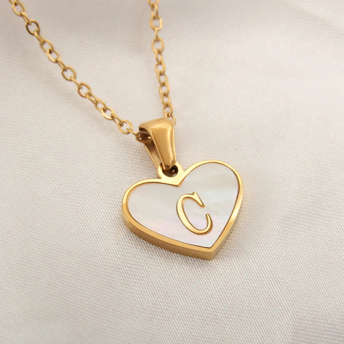 Gold plated chain necklace with a white shell heart-shaped pendant personalised with a single letter initial.