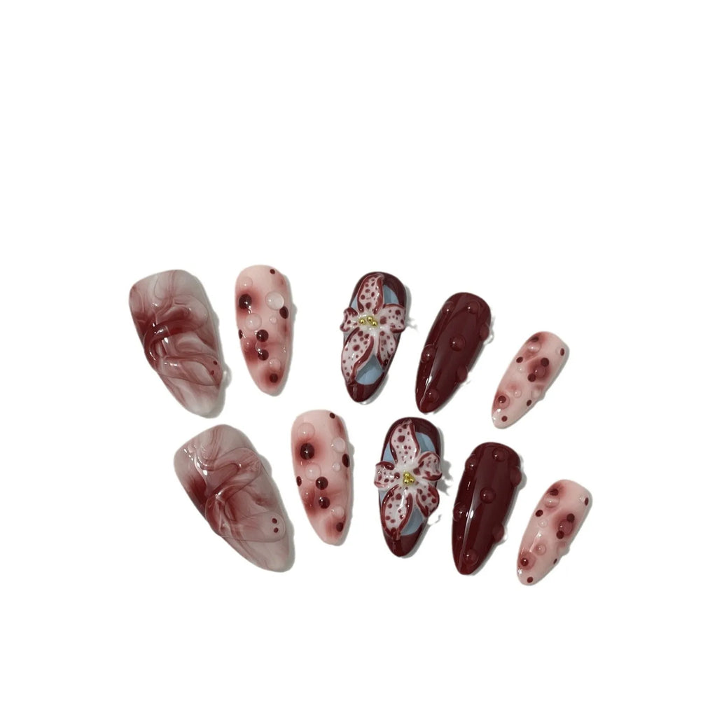 Hand-painted 3D carved press-on nails in mid-length almond shape with floral and pattern designs.
