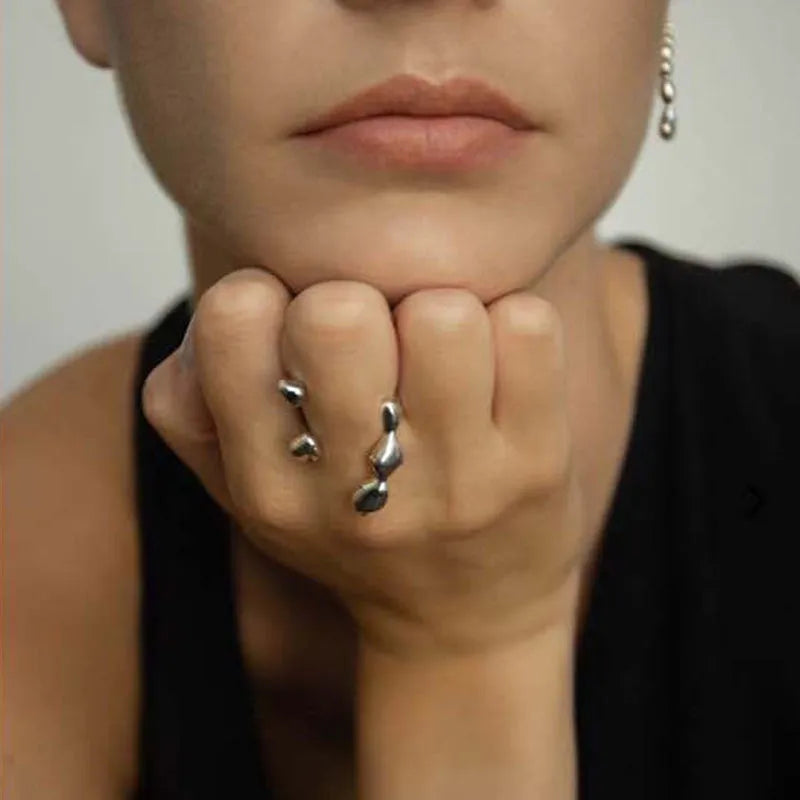 Gold tone brass opening ring with spherical circular design on a finger.