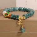 Blue water jade abacus beads bracelet with white agate, butterfly motifs and rhinestone accents on alloy band