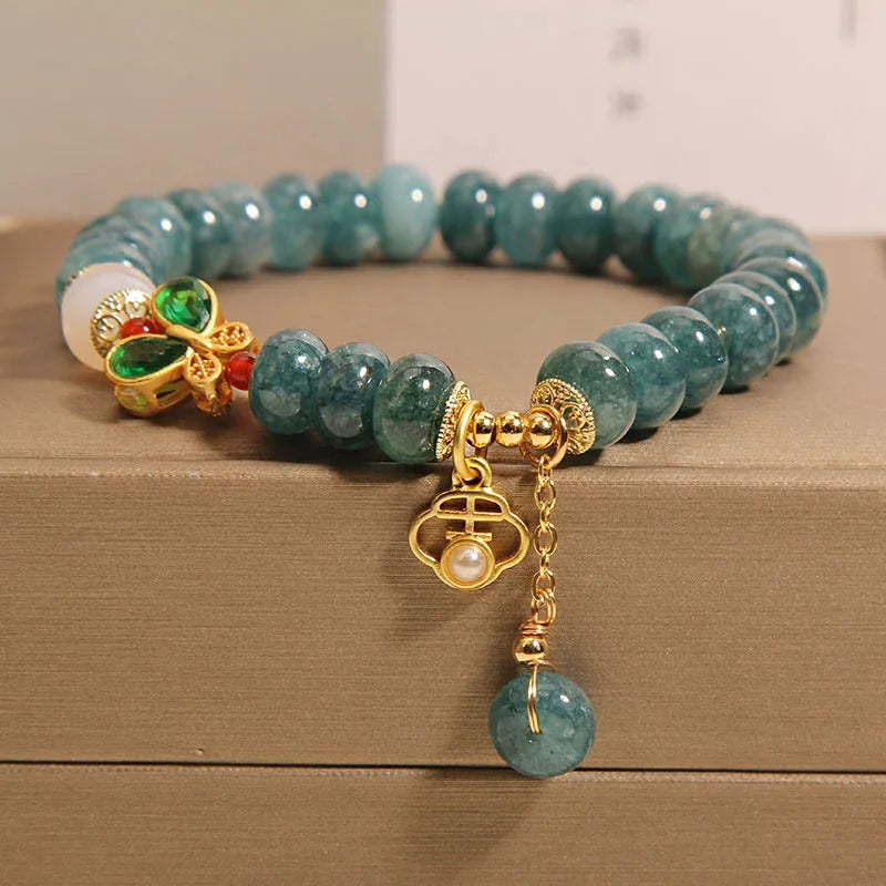 Blue water jade abacus beads bracelet with white agate, butterfly motifs and rhinestone accents on alloy band