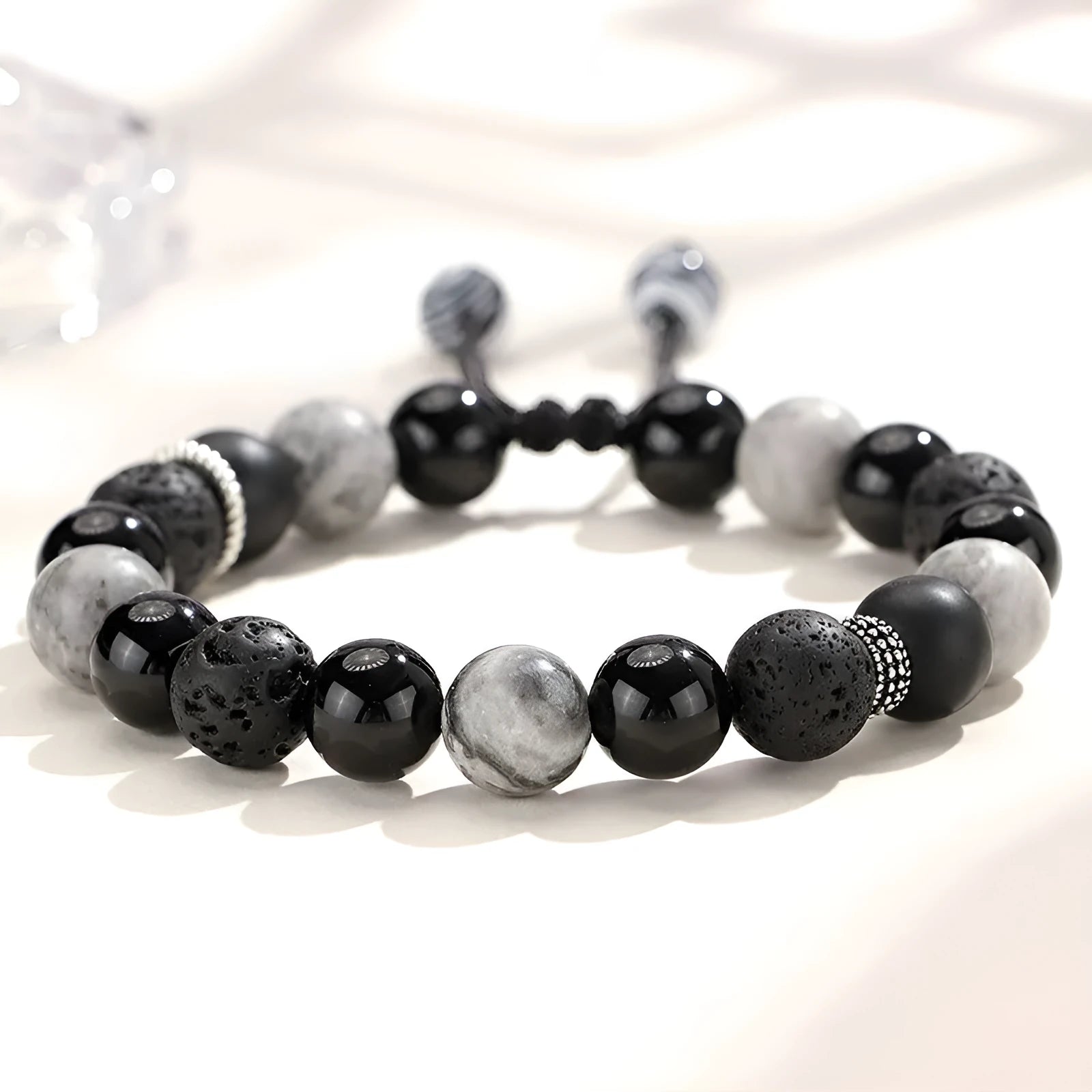 Black agate map stone volcanic rock bracelet with diamond-shaped cuts on wrist.