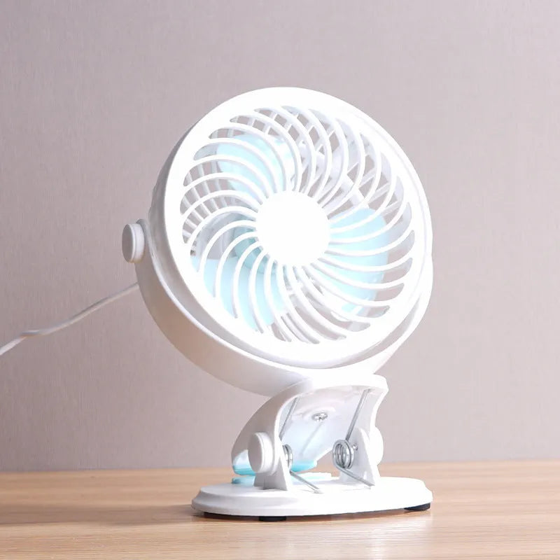 Small USB desktop fan in white plastic with three blades, shown as both clip-mounted and floor-standing versions