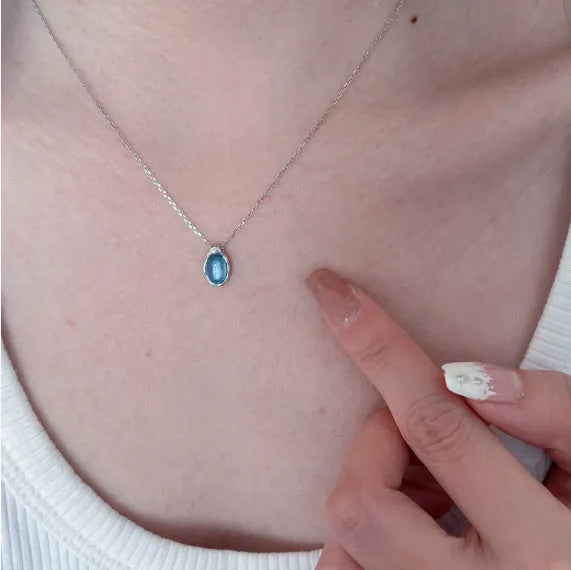 Navy blue water drop necklace with platinum accents on adjustable cross chain