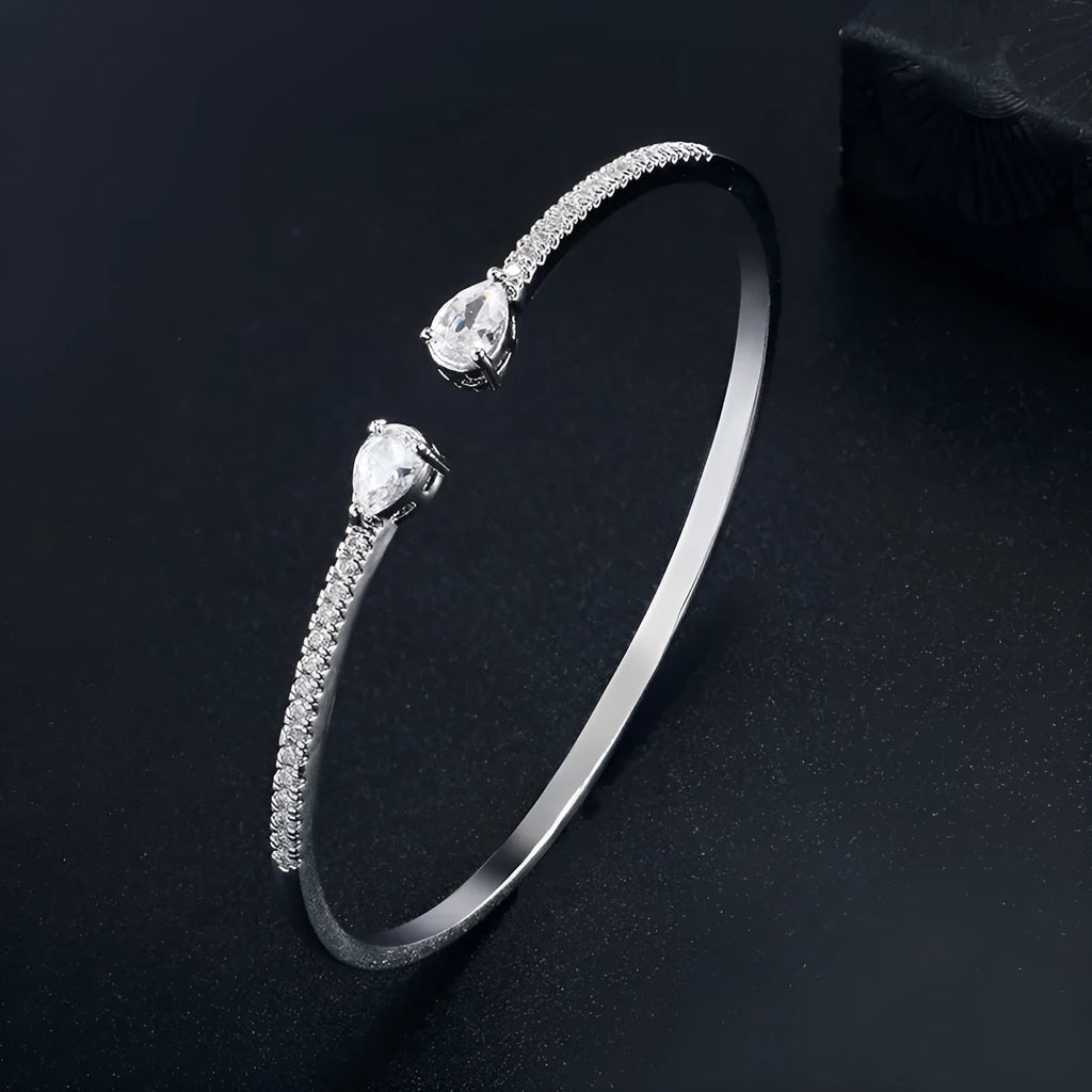 Adjustable copper bracelet with inlaid white zircon stones on a wrist.