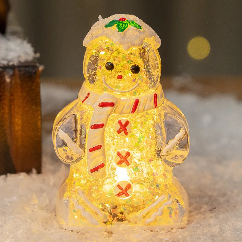 Glowing LED gingerbread man and snowman Christmas ornaments with coloured scarves on a festive tree branch.