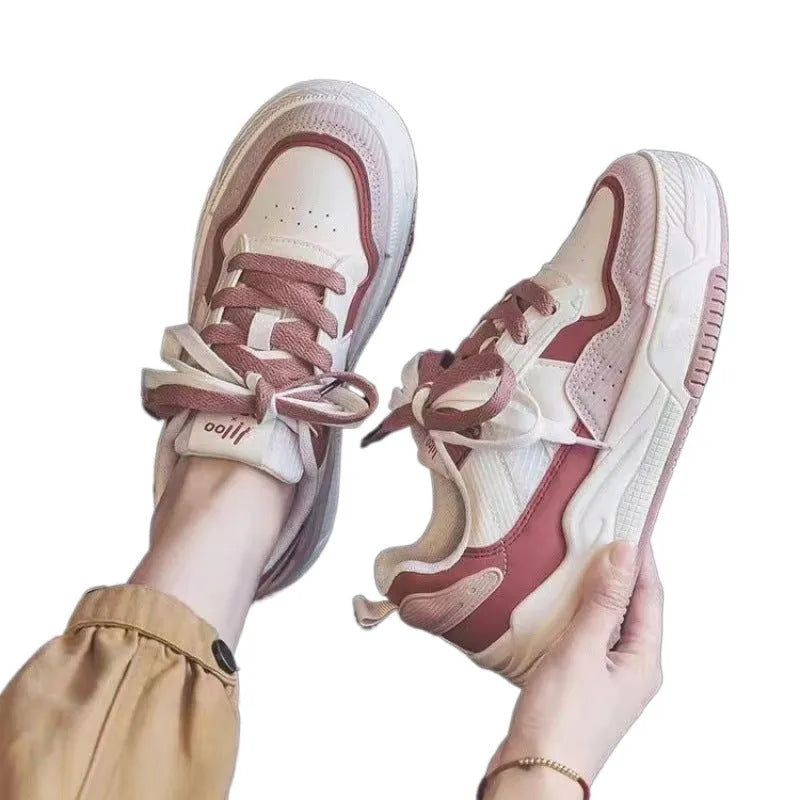 Women's pink and beige low-top sneakers with a rubber sole for height increase.